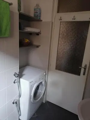 a small bathroom with a washing machine and a window at Andreja apartman 2 (jednosobni app -50m2) in Belgrade