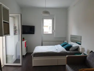a bedroom with a bed with blue pillows and a mirror at Studio Apartment 