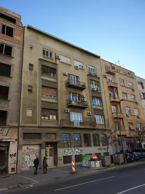 a tall building with people walking in front of it at Studio Apartment 