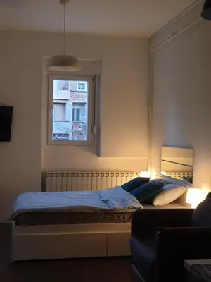 a bedroom with a bed and a window at Studio Apartment 