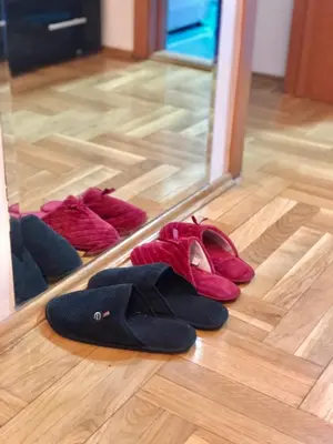 a group of shoes on the floor in front of a mirror at BellaVista Apartmani in Stara Pazova