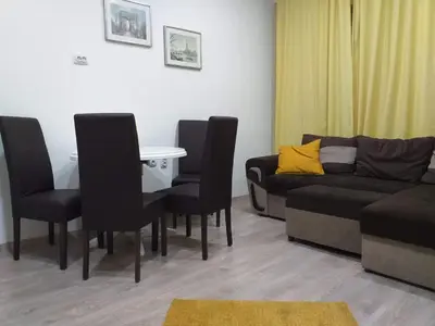 a living room with a couch and a table and chairs at Belvedere Skadarska Apartment in Belgrade