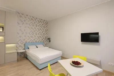 a bedroom with a bed and a table and a tv at Belgrade Center Apartment VI in Belgrade