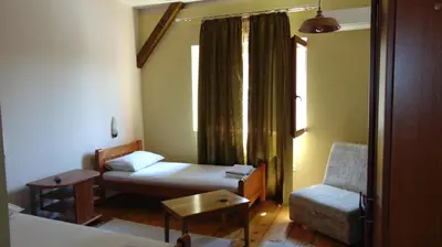a room with two beds and a chair and a window at Rooms Milin Lagum in Irig