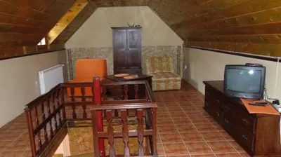 a living room with a tv and a chair at Rooms Milin Lagum in Irig