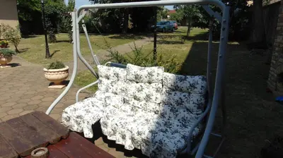 a swing with pillows on it in a yard at Rooms Milin Lagum in Irig