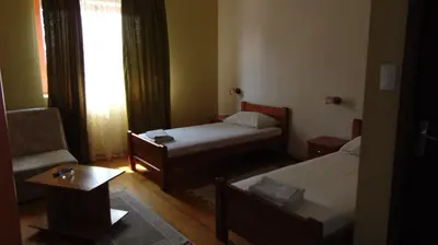 a small room with two beds and a chair at Rooms Milin Lagum in Irig