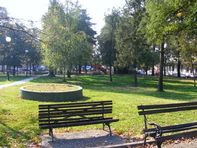 two park benches in a park with a fountain at Rooms Milin Lagum in Irig