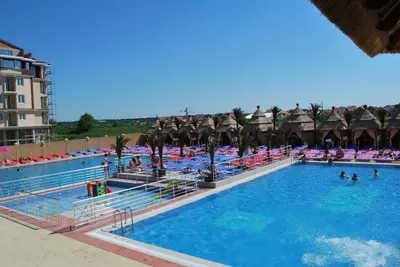 a large swimming pool with chairs and people in it at Kengur Resort in Belgrade