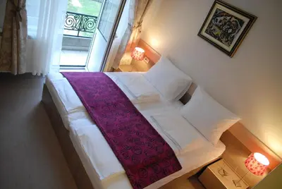 a bedroom with a white bed with a red blanket at Apartments Legacy in Belgrade