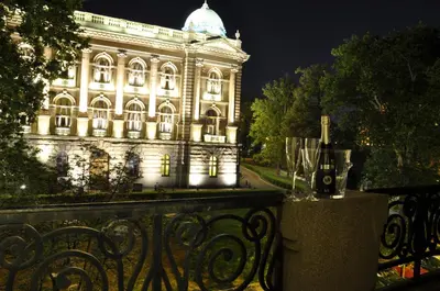 a building lit up at night in front of a fence at Apartments Legacy in Belgrade