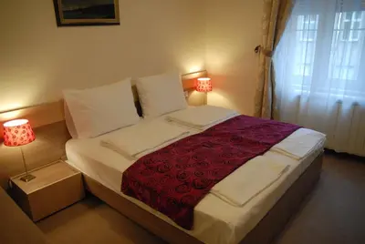 a bed in a bedroom with two lamps on at Apartments Legacy in Belgrade