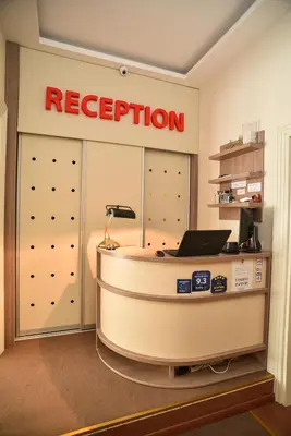 a reception desk in a room with a red evacuation sign at Apartments Legacy in Belgrade
