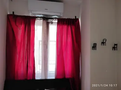 a window with red curtains in a room at Retro Mini Apartment in Zemun