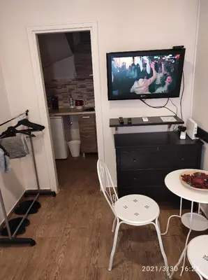 a living room with a tv and a table and chairs at Retro Mini Apartment in Zemun