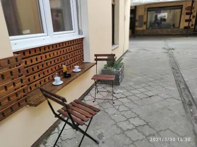 two chairs and a table on the side of a building at Retro Mini Apartment in Zemun