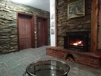 a living room with a brick fireplace and a table at Vila Ana in Donja Ralja