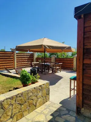 a patio with tables and a large umbrella at Vila Ana in Donja Ralja