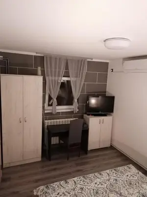 a room with a table and a kitchen with a microwave at DEP House in Zemun