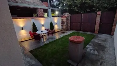 a small backyard with a table and chairs and lights at DEP House in Zemun