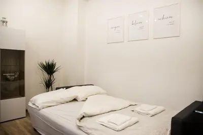 a white bedroom with a bed with towels on it at 4Seasons in Sajmište