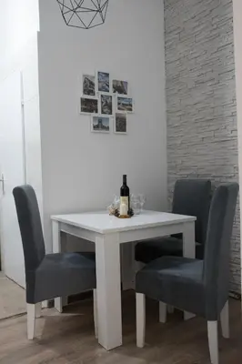 a white table with chairs and a bottle of wine on it at 4Seasons in Sajmište