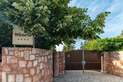 a gate to a villa with a brick fence at Villa Wisteria in Smederevo