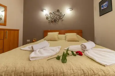 a bedroom with a bed with towels and roses on it at Villa Wisteria in Smederevo