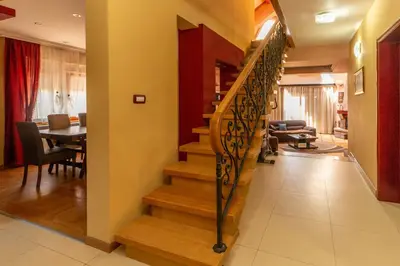 a living room with a staircase and a dining room at Villa Wisteria in Smederevo