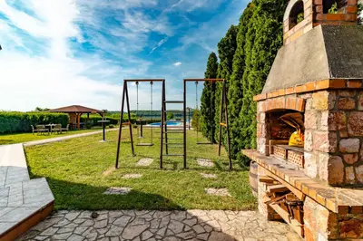 an outdoor play area with a playground and a stone oven at Villa Wisteria in Smederevo