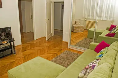 a living room with a couch and a mirror at See U in Belgrade in Belgrade
