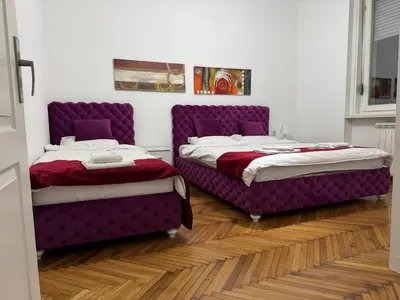 two beds in a room with purple furniture at Apartment Marsal in Belgrade