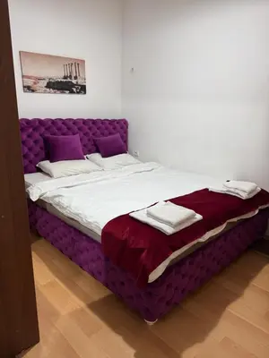 a large bed with a purple bed frame in a room at Apartment Marsal in Belgrade