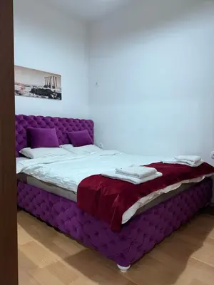 a bed with a purple bed frame in a room at Apartment Marsal in Belgrade
