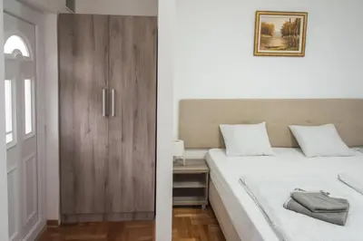 a bedroom with a bed and a wooden cabinet at APARTMAN TEA in Belgrade
