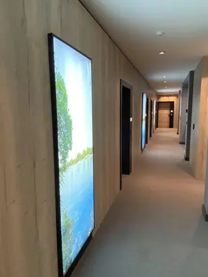 a large television on a wall in a hallway at Super seven inn in Belgrade