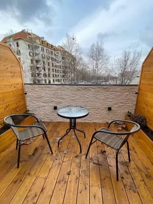 two chairs and a table on a wooden deck at Super seven inn in Belgrade
