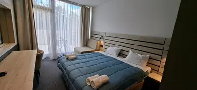 a bedroom with a blue bed and a large window at Super seven inn in Belgrade