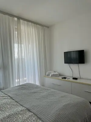 a bedroom with a bed and a flat screen tv at MANHATTAN APARTMAN Belvil in Belgrade