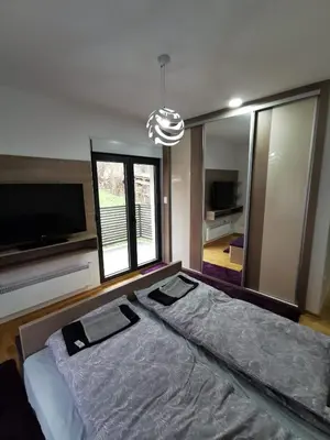 a bedroom with a large bed and a large window at Porto23 in Belgrade