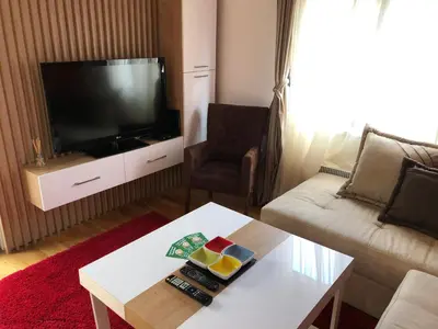 a living room with a tv and a couch and a table at Porto23 in Belgrade