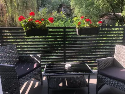 a patio with two chairs and a table and flowers at Porto23 in Belgrade