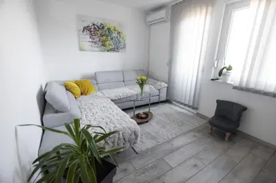 a living room with a couch and a chair at Apartman ISKRA in Arandjelovac
