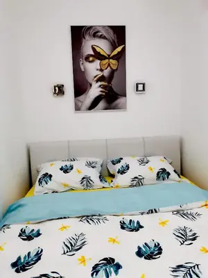 a bedroom with a bed with a butterfly picture on the wall at Apartman ISKRA in Arandjelovac