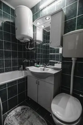 a bathroom with a toilet and a sink and a mirror at Apartman ISKRA in Arandjelovac