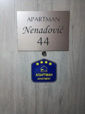 a sign for the american neanderthal actowment on a wooden door at Nenadovic Apartman in Obrenovac