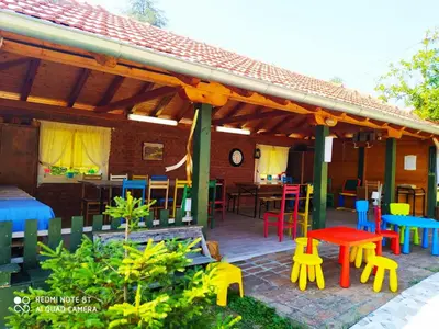 a patio with colorful tables and chairs under a roof at Dečiji vinogradi Belgrade, Sopot, Kosmaj in Sopot