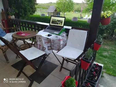 a laptop computer sitting on a table with two chairs at Dečiji vinogradi Belgrade, Sopot, Kosmaj in Sopot