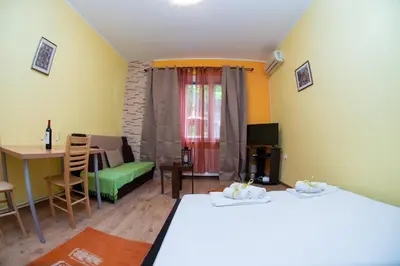 a room with two beds and a table and a chair at Apartment Kalemegdan in Belgrade