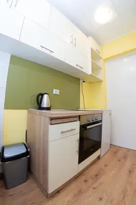 a kitchen with white cabinets and a trash can at Apartment Kalemegdan in Belgrade